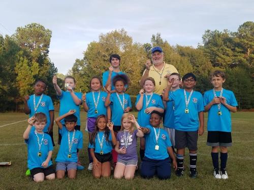 Rotarian Bob Patterson presenting 4 way test coin to Elementary School Soccer Students.jpg