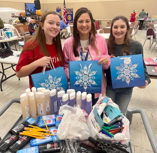 Manchester Middle School Interact Teacher and two students help create Christmas Bags for Seniors.jpg