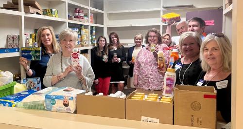 Rotarian showing off items in the Dorcus Food and Supply Pantry.jpg