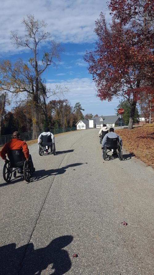 Participants pushing up the hill in a wheelchair.jpg