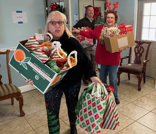 Lisa Thompson, Cynthia Kilby and Bart Fuller carring Santa Gifts for Seniors.jpeg